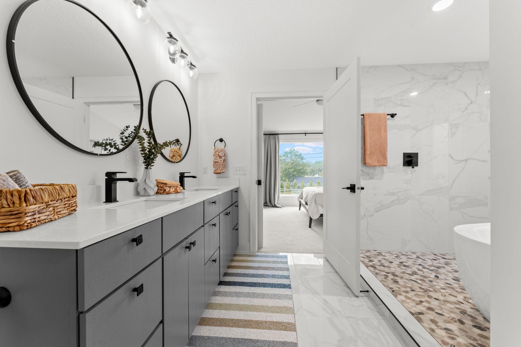 The spacious primary bathroom offers a double vanity and direct access to the walk in closet
