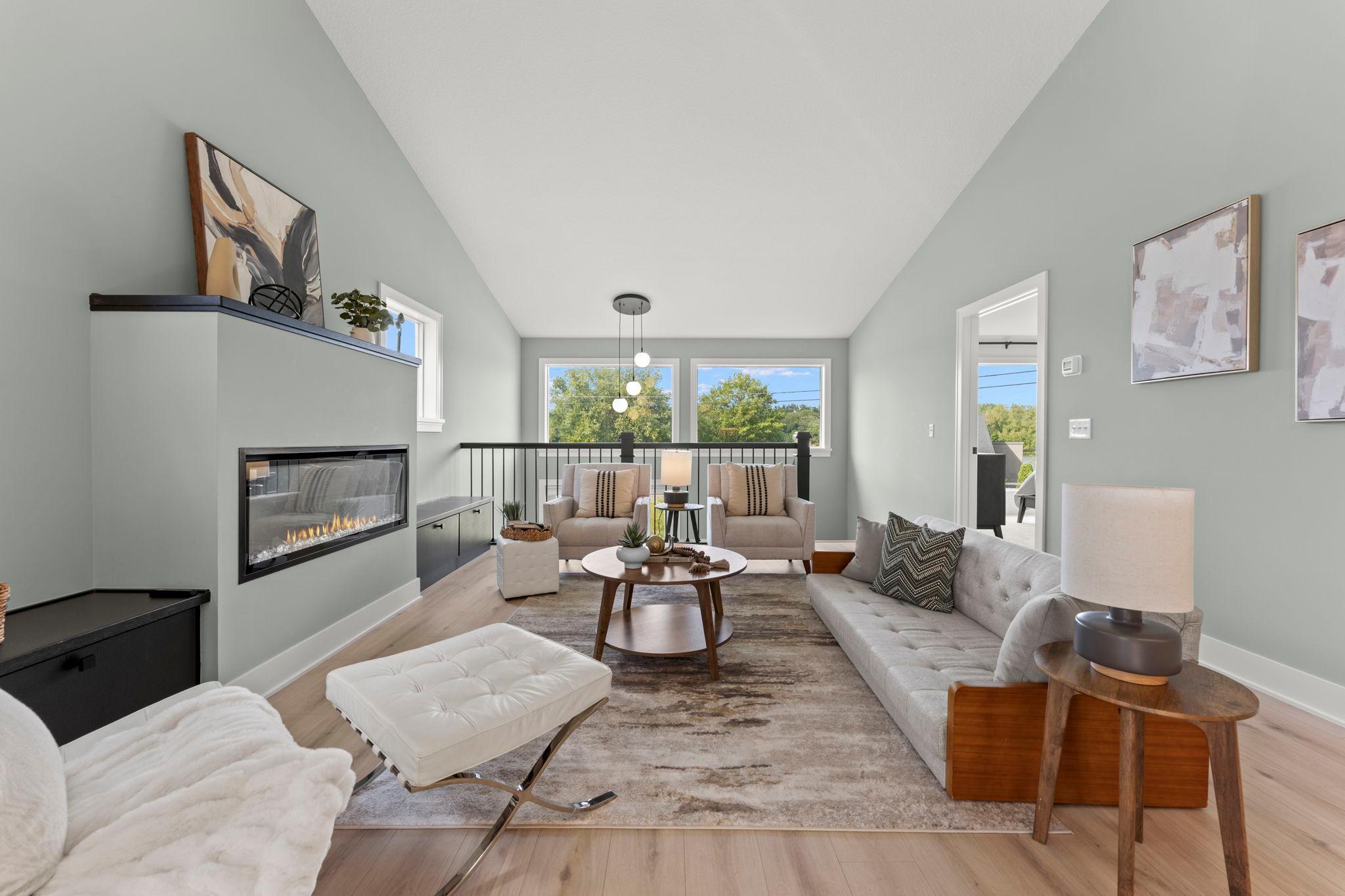 The inviting living room features a modern fireplace and beautiful outdoor views