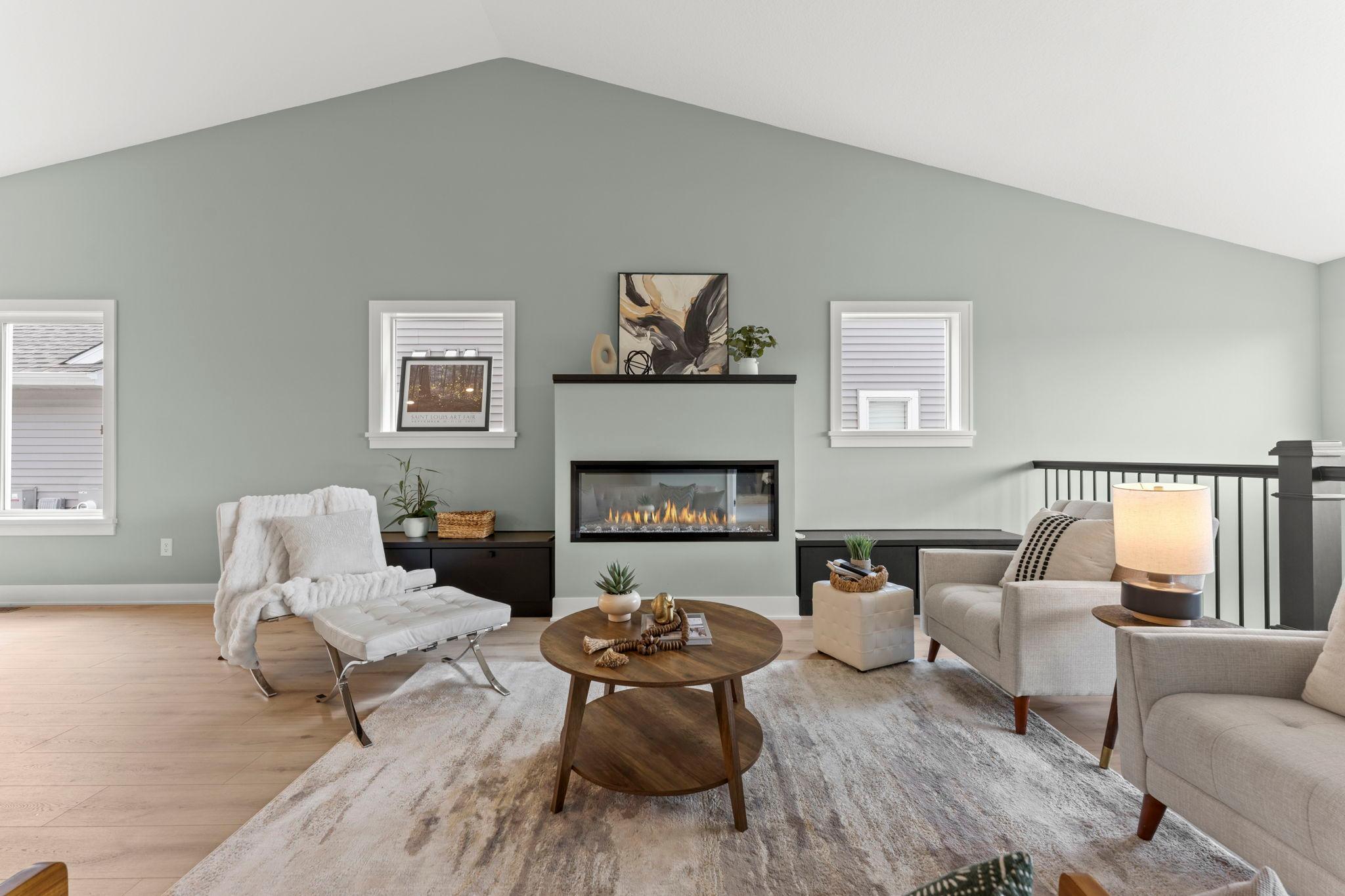 The living room offers a comfortable gathering space with soaring ceilings and a modern fireplace