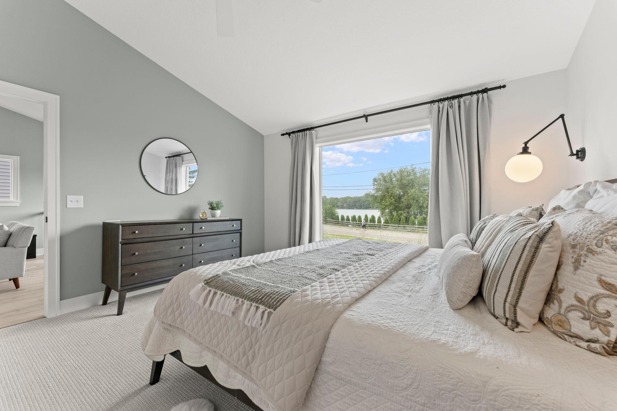 Wake up to beautiful natural light and tranquil lake views from the primary bedroom