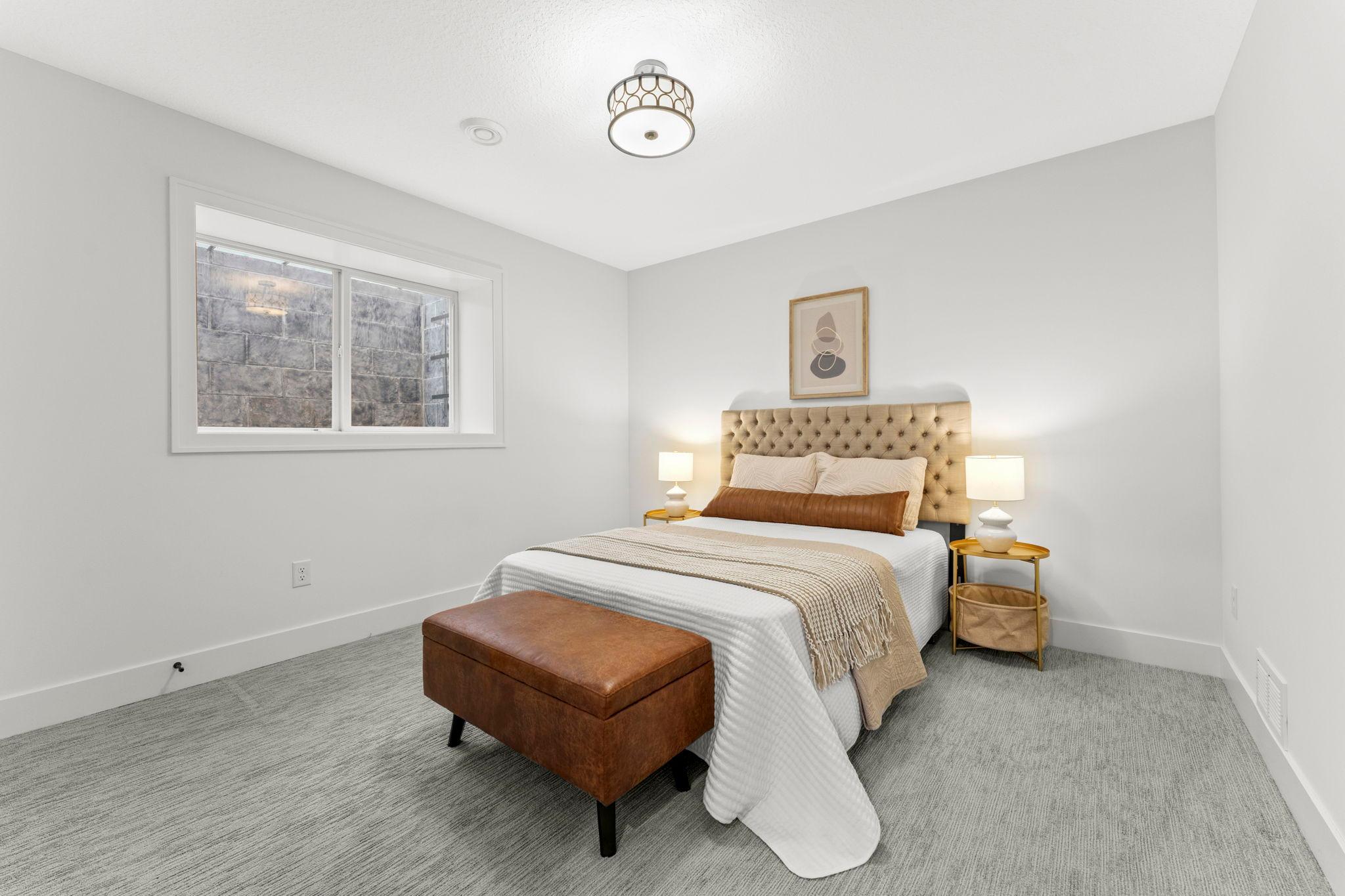 Bright and comfortable lower level bedroom with a large window
