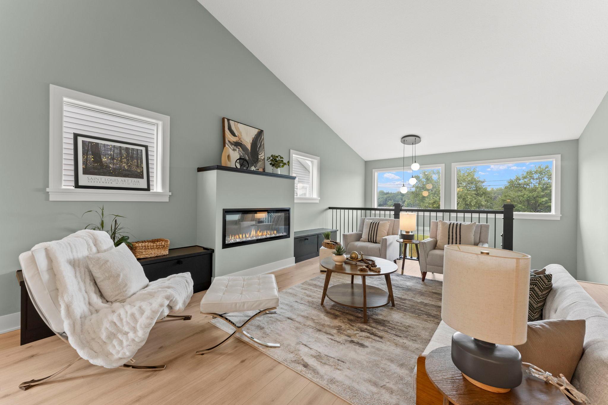 Relax beside the fireplace while enjoying peaceful views through the large windows
