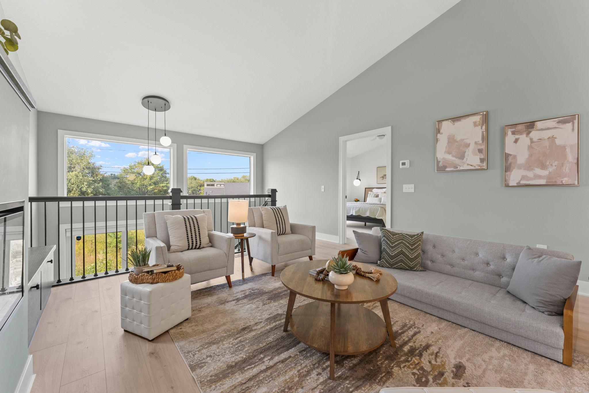 Large windows and a soaring ceiling create a bright and inviting living room