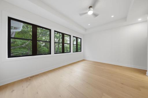 Photo of similar model - large wall of windows in primary bedroom overlooking backyard