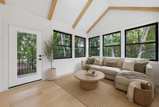 Virtually staged sunroom off of living room.