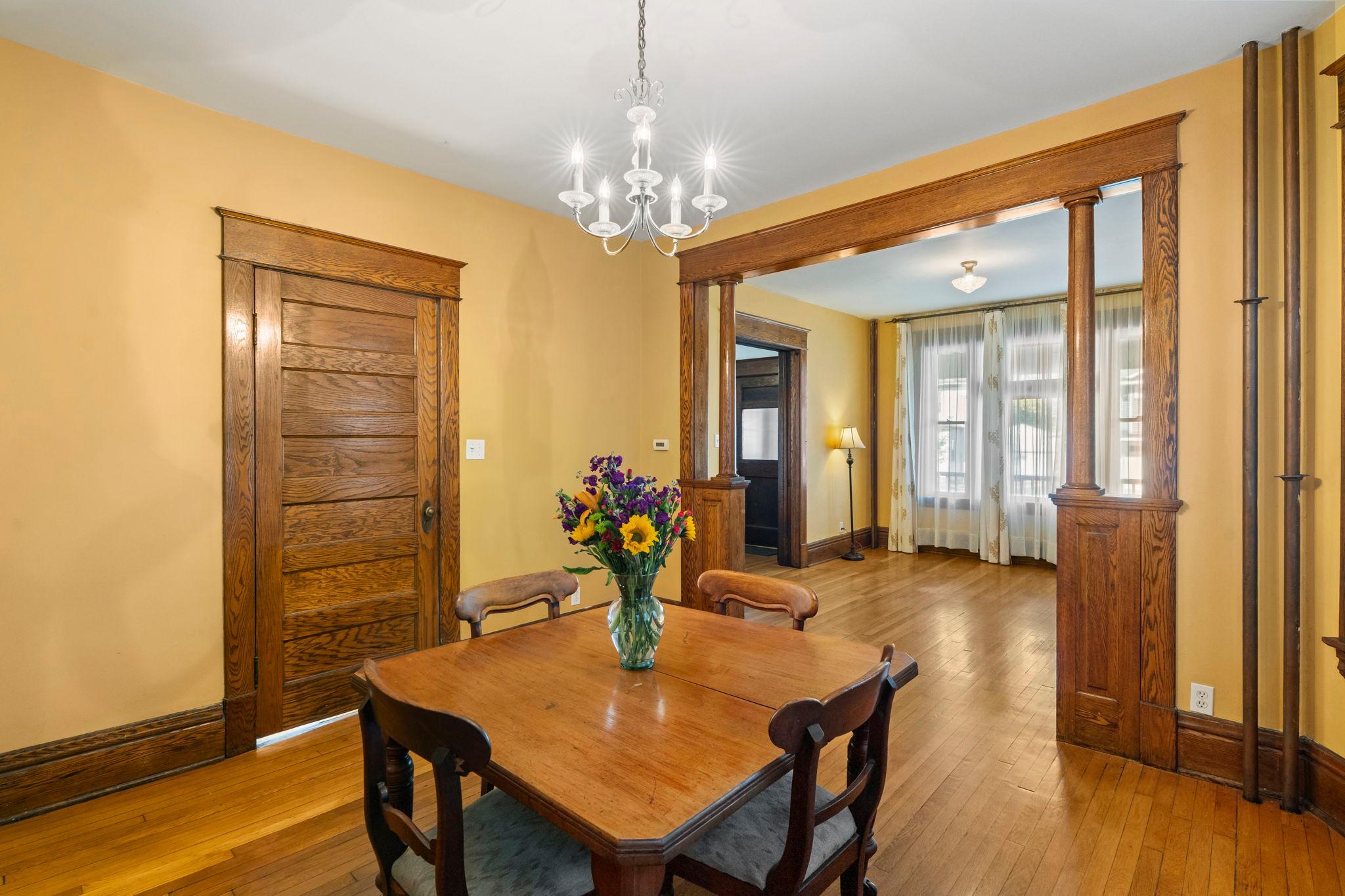 View from the dining room to the living room on the right. The kitchen door is behind the wooden door on the left.