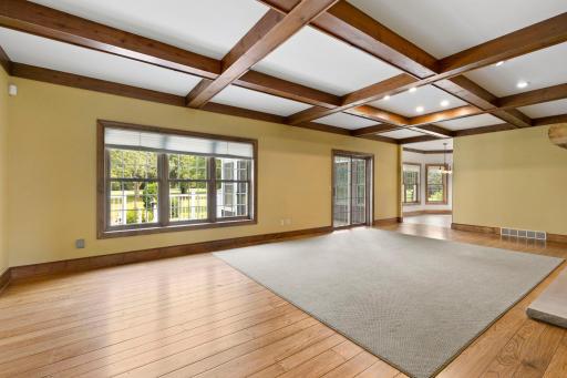 The accent ceiling is complete with wooden beams overhead within the main living room.