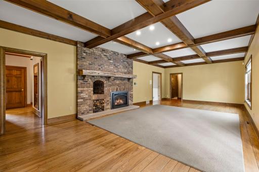 The main level living room is complete with a gas fireplace with a high-end Hearth and Home insert, set within a rustic railroad tie mantle and masonry surround.