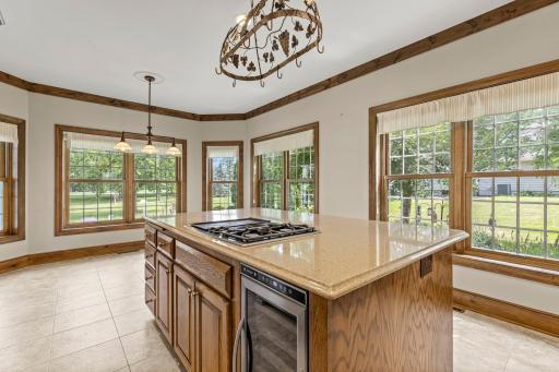 Stunning center kitchen island with a wine cooler, gas cooktop and Cambria countertops.