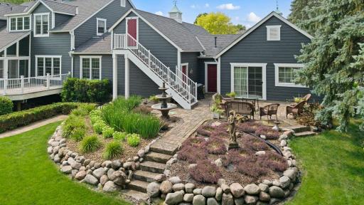Stunning well maintained landscaping throughout, with external staircase leading to storage above the garage.