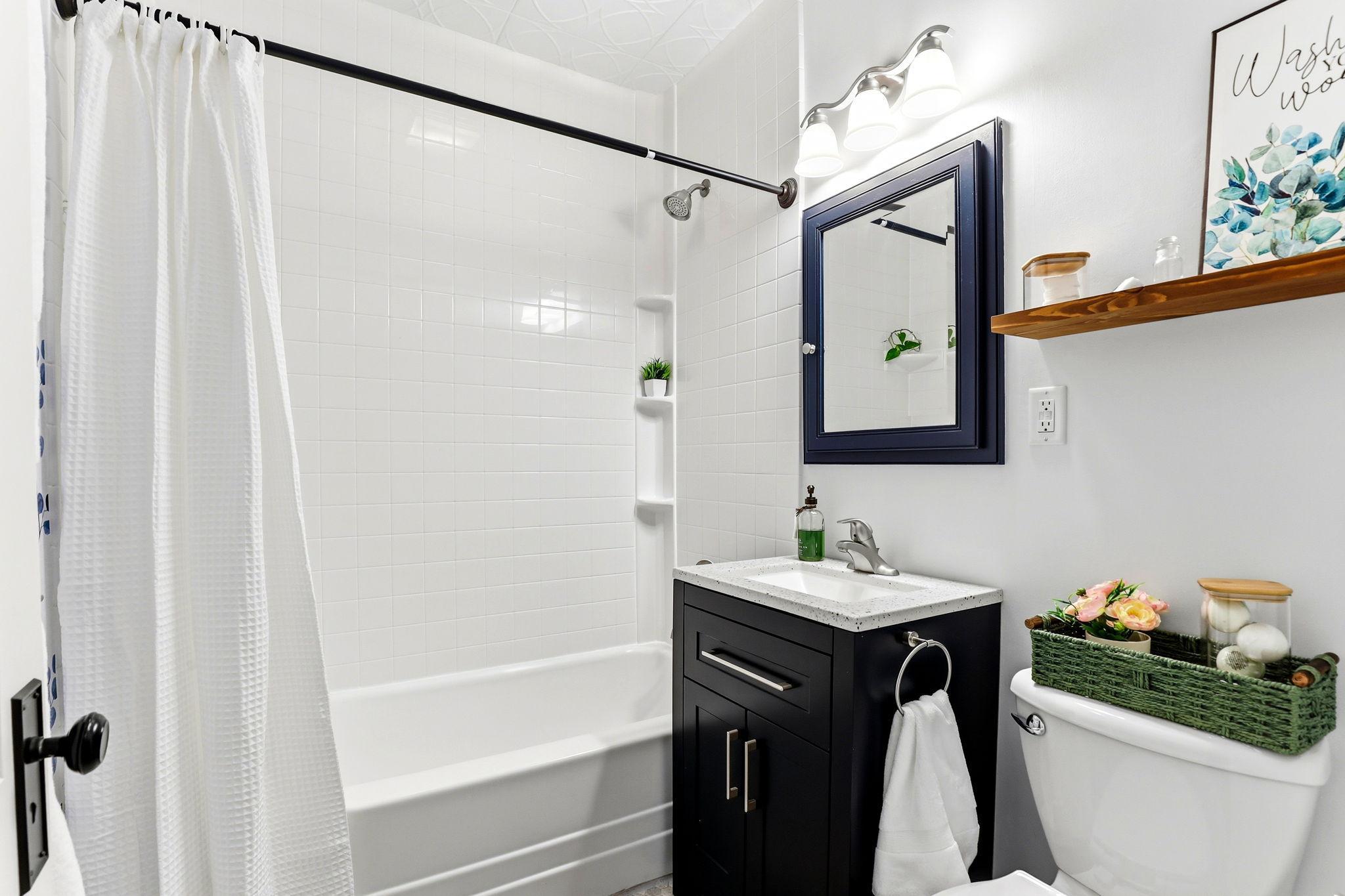 Bathroom remodel includes NEW tile, NEW sleek vanity, and NEW toilet. (2025)
