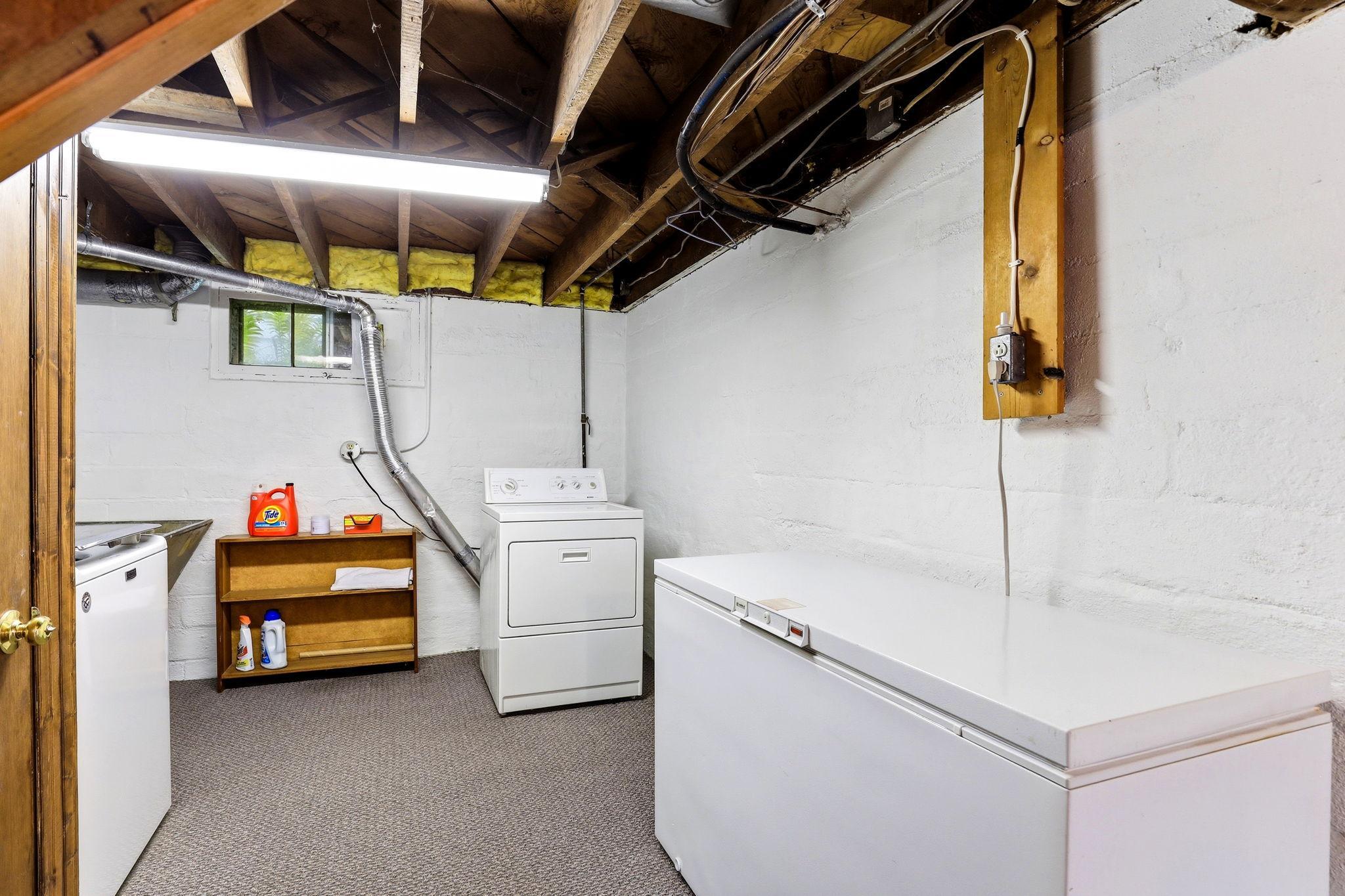 Functional lower-level laundry and utility area with ample room for storage.
