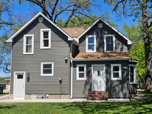 Back of home. South East Entrance opens to enclosed porch. Old porch roof removed entirely and new pitched roof added 2022. SW Door opens to kitchen and stairwell to LL.