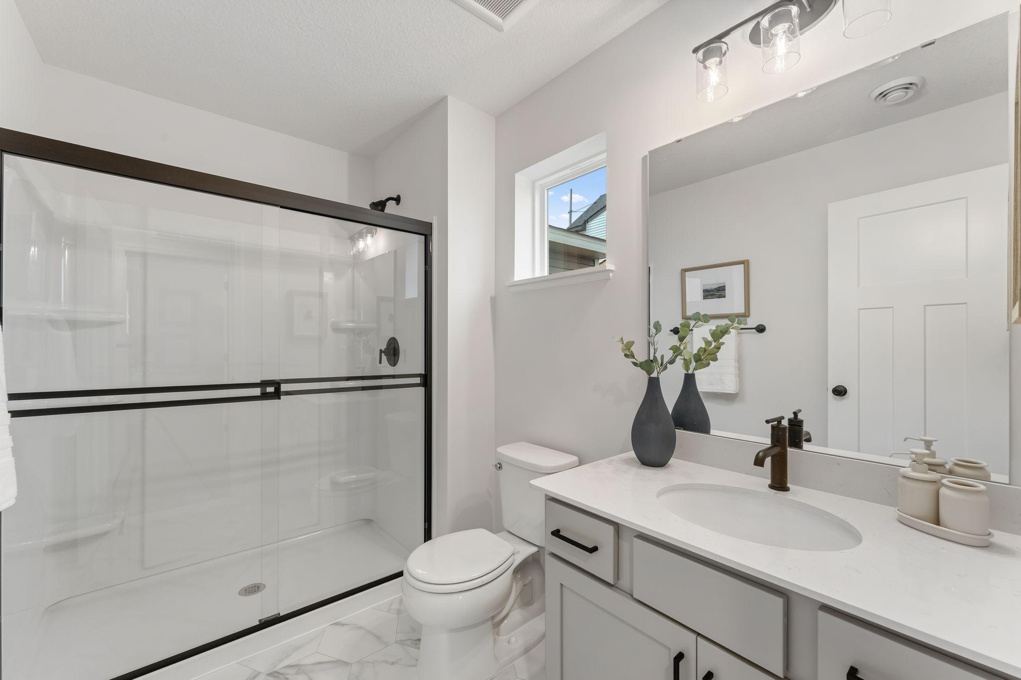 This stylish main level 3/4 bathroom complete with soft-close cabinets & drawers is conveniently located across the hall from the main floor bedroom! (Picture for representation only, colors and materials may vary in actual home.)