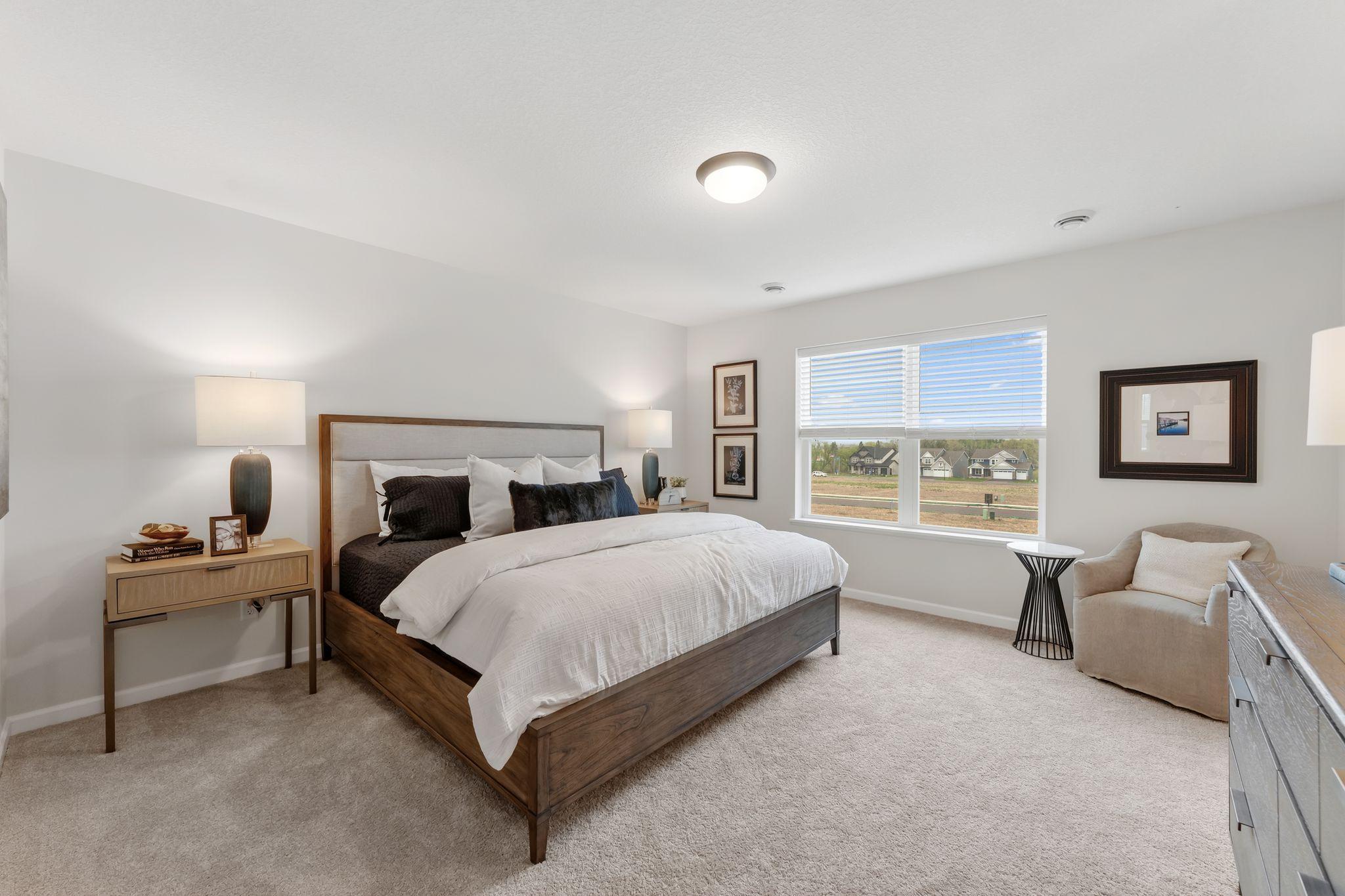 The primary bedroom offers plush carpeting, stylish overhead lighting, large windows, spacious walk-in closet & private BA! (Picture for representation only, colors and materials may vary in actual home.)
