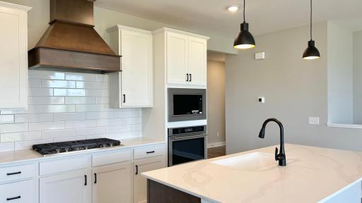 Large island, vented hood, 5-burner gas cooktop AND abundant cabinet/counter space - chef's dreams come true! Photo of actual home.
