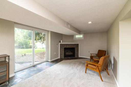 Family Room with Gas Fireplace and Patio Door to Backyard Patio and Fenced Yard