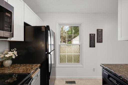 Kitchen window adds natural light while the efficient layout keeps appliances, storage, and workspace within easy reach.