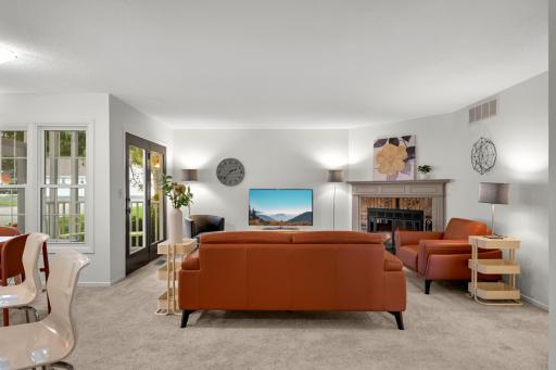 Spacious living room with neutral finishes, abundant natural light, and a brick fireplace serving as an inviting focal point.