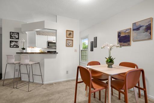 Open dining area flows naturally into the kitchen and living room, with breakfast-bar seating adding flexibility.