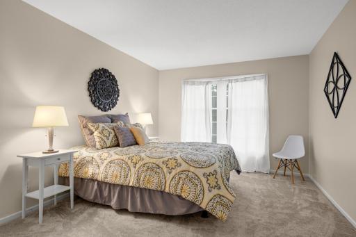 Comfortable primary bedroom with warm neutral finishes and plenty of space for bedside furnishings.