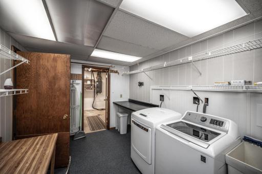 The laundry room is large and has storage rooms on either end of it