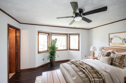 This photo has been virtually staged. The main level primary bedroom is a nice size and has a bump-out overlooking the backyard.