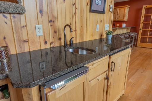 Main floor wet bar with granite counter tops and custom cabinetry