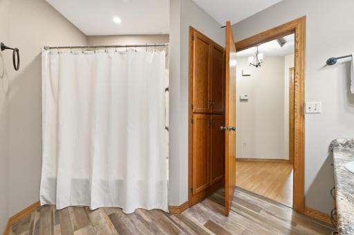 View of the main floor full bathroom tub/shower and built-in linen closet.
