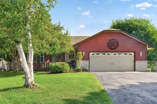 The front exterior features mature trees and planting beds.
