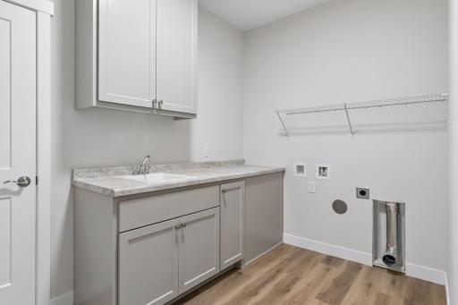 Dedicated laundry room with sink and storage