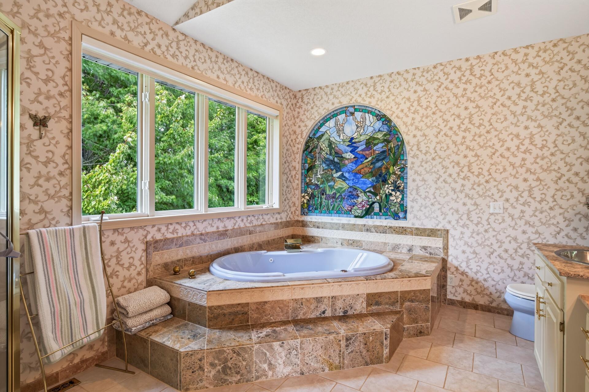 Soaking tub with peaceful views of the property