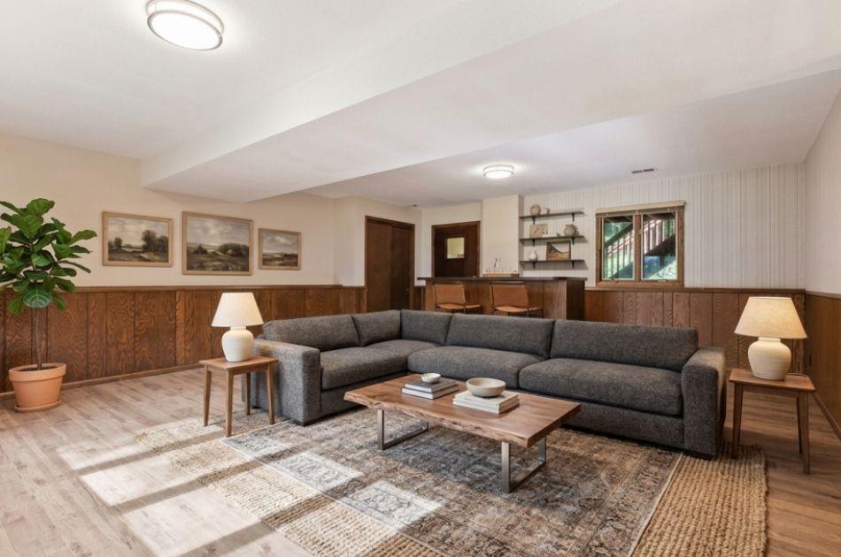 The lower-level family room offers a generous bar area and stylish LVP flooring—perfect for entertaining or everyday relaxation. (Virtually Staged)