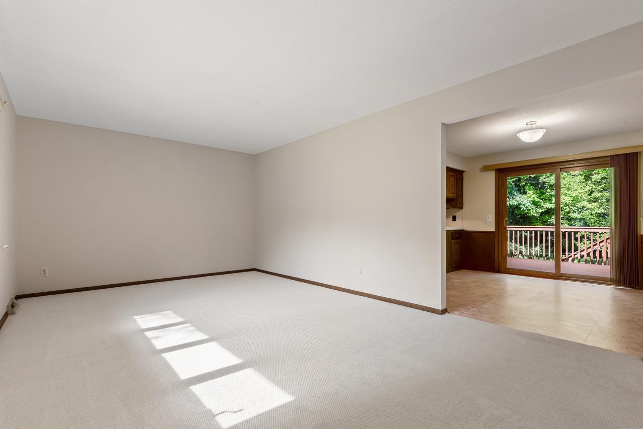 The living room is open to the dining area, with new carpet and fresh paint throughout the main level.
