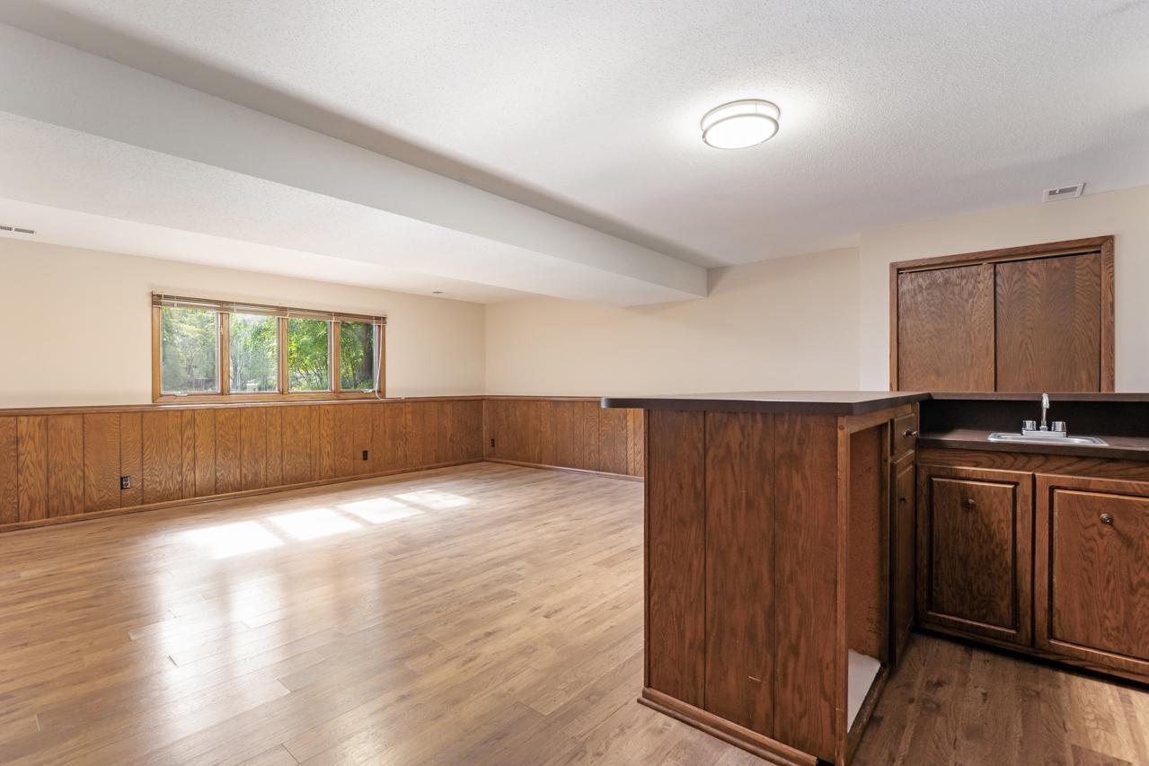 The inviting lower-level family room includes a bar with a convenient sink and room for a refrigerator—perfect for entertaining.