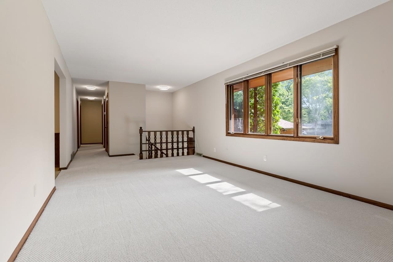 The upper-level living room leads into the hallway to the bedrooms and bathroom and sits adjacent to the front entry steps from the foyer.