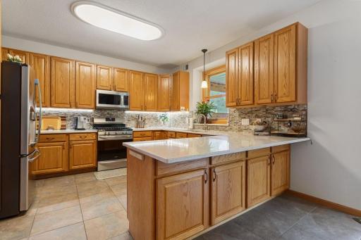 Beautifully remodeled, large kitchen with granite counters, glass-tile backsplash, pendant lighting, under-cabinet lighting, stainless steel appliances, soft-close cabinets and a convenient Lazy Susan for easy storage. (New range, 2020.)