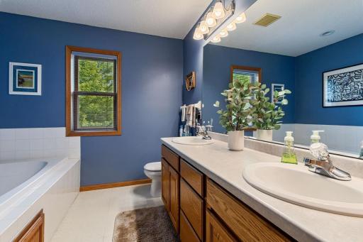 The spacious primary ensuite features a double vanity, separate glass-enclosed shower and relaxing soaker tub. A linen closet with a built-in hamper door adds convenient storage and everyday functionality.