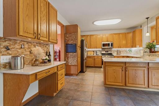 The kitchen offers a convenient dedicated desk area with upper cabinetry, providing a practical spot for homework, meal planning, or staying organized while keeping everything close at hand.