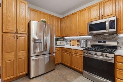Beautiful cabinetry, generous counter space and a large pantry with convenient pull-out drawers provide exceptional storage and functionality. Plenty of room to prep, organize and enjoy everyday cooking in this inviting kitchen.
