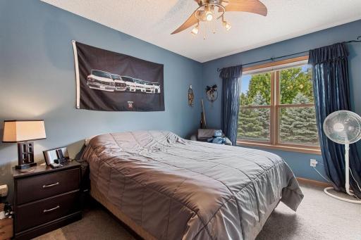 Bright and inviting upper-level bedroom featuring beautiful backyard views, a ceiling fan, and a nicely sized closet. A comfortable space with plenty of room to create a bedroom, guest retreat, or personal space.