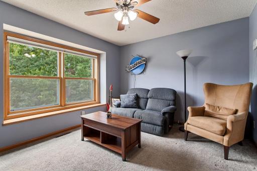 Bright south-facing upper-level bedroom currently enjoyed as a cozy sitting room, showcasing the versatility of this spacious bedroom. Large windows bring in beautiful natural light, making it equally well suited for relaxing.