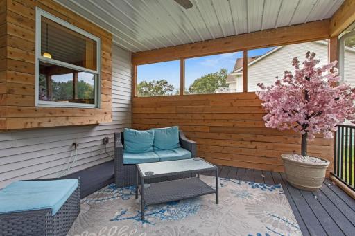 Beautiful 2022-built screened porch featuring maintenance-free Trex Select decking, an aluminum ceiling, ceiling fan, and rustic knotty pine tongue-and-groove accent wall—an inviting space to relax and enjoy the outdoors in comfort.