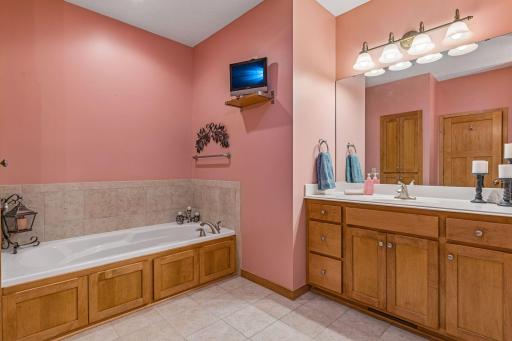 Tile flooring and a soaking tub in the private primary bathroom.