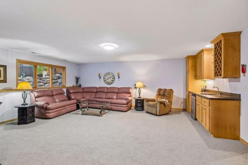 Family room in the lower level with look-out windows includes wooden blinds.