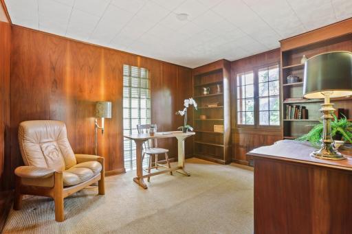 Main Floor Den - This addition was built by the Wickstroms and could function beautifully as a non-conforming bedroom or home office. Featuring beautiful wood paneling and built-in bookshelves, it's a warm, versatile space.