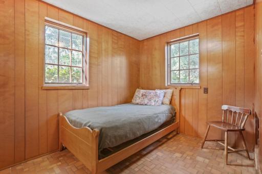 Bedroom #4 - This room is off of the kitchen and has beautiful wooden paneling and original tile flooring that is in perfect condition. This room has 2 windows that look into the backyard and side of the house.