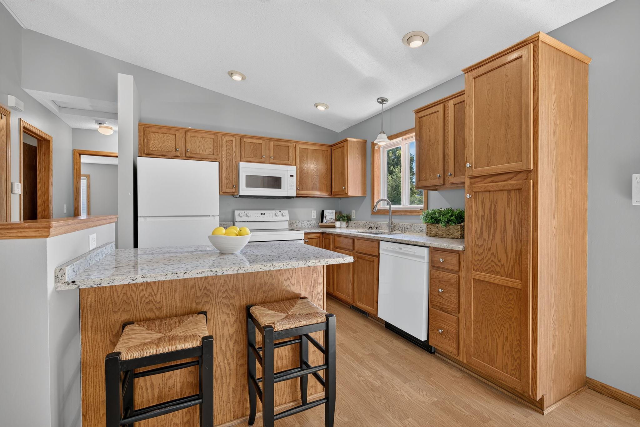 Bright and spacious kitchen featuring brand-new granite countertops and new appliances, with plenty of cabinetry, generous counter space, and an open layout perfect for everyday living and entertaining.