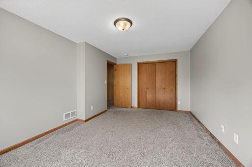Bright and clean lower-level bedroom featuring spacious closets with plenty of room for storage.