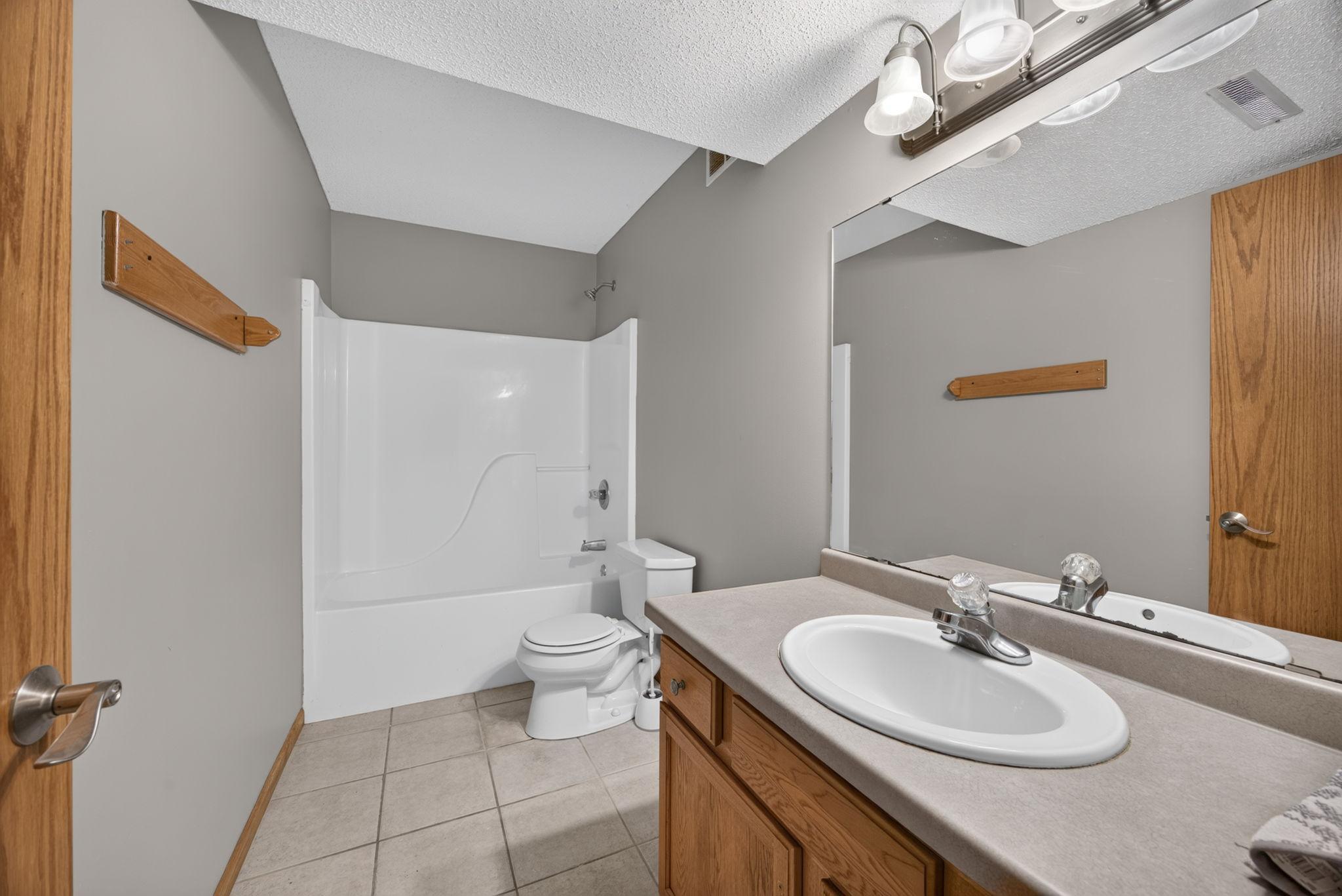 Convenient lower-level full bathroom featuring a tub/shower combination and plenty of space for everyday use or guests.